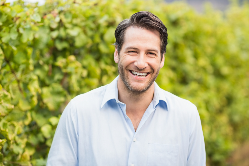 Young happy man smiling at camera in the grape fields-1